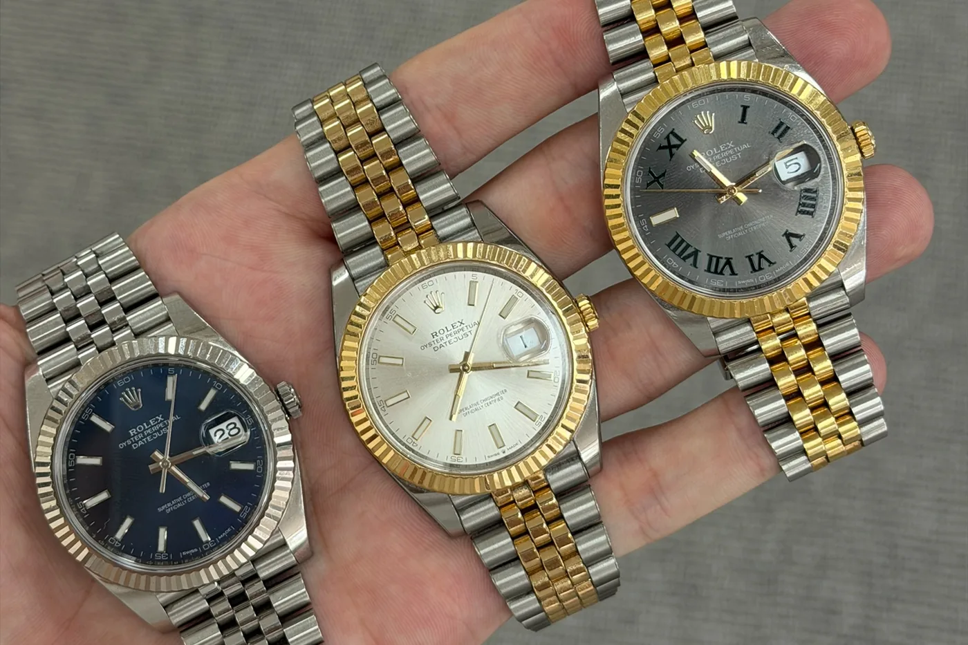Three Rolex Datejust watches held side by side during watch authentication in Melbourne