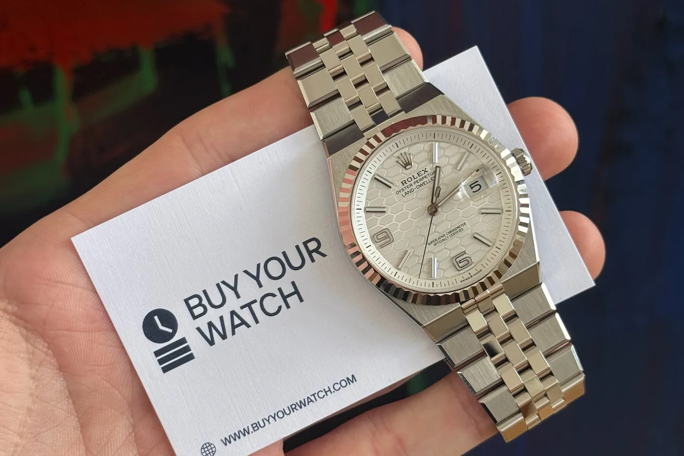 Rolex Oyster Perpetual Land-Dweller held with a Buy Your Watch card
